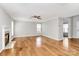 Open living room features hardwood floors, a ceiling fan, and a cozy fireplace at 147 Amber Woods Dr, Tega Cay, SC 29708