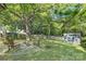 Expansive backyard featuring a fire pit with seating area beneath a large tree with a gray storage shed at 1509 Harrill St, Charlotte, NC 28205