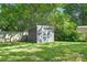 Backyard featuring a gray storage shed and fenced in yard, surrounded by lush greenery at 1509 Harrill St, Charlotte, NC 28205