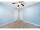 Cozy bedroom featuring blue walls, neutral carpet, ceiling fan, and two white doors at 1509 Harrill St, Charlotte, NC 28205