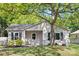 Charming single-story home featuring a well-manicured lawn, mature tree, and quaint front porch at 1509 Harrill St, Charlotte, NC 28205