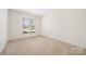 Bright, carpeted bedroom with a large window and neutral color scheme at 16312 Redstone Mountain Ln, Charlotte, NC 28277