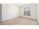 Bright, carpeted bedroom with a large window and neutral color scheme at 16312 Redstone Mountain Ln, Charlotte, NC 28277