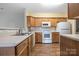 Clean kitchen featuring wooden cabinets, laminate countertops, updated backsplash, and modern appliances at 16312 Redstone Mountain Ln, Charlotte, NC 28277