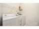 Bright laundry room featuring a washer, dryer, and wire shelving for optimal storage at 16312 Redstone Mountain Ln, Charlotte, NC 28277