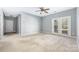 Bright living room with double doors to balcony, ceiling fan and neutral paint at 16312 Redstone Mountain Ln, Charlotte, NC 28277