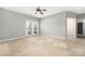 Spacious main bedroom featuring double doors to balcony, ceiling fan and neutral paint at 16312 Redstone Mountain Ln, Charlotte, NC 28277