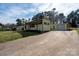 Charming yellow home with a long driveway and a lush green lawn surrounded by mature trees at 1909 Stokes Ferry Rd, Salisbury, NC 28146