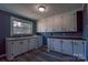 Bright kitchen with white cabinets, laminate countertops, and a large window overlooking the front yard at 1909 Stokes Ferry Rd, Salisbury, NC 28146