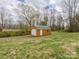 Backyard with large shed building for storage on a partly cloudy day with blue sky at 207 Sigmon Rd, Statesville, NC 28677