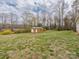 Large yard with shed and house in distance on a partly cloudy day with blue sky at 207 Sigmon Rd, Statesville, NC 28677