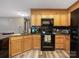 Modern kitchen featuring wood cabinets, black appliances, and stainless steel sink at 207 Sigmon Rd, Statesville, NC 28677