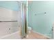 Neat bathroom with tiled floor, shower and tub combo and blue colored walls at 232 Faust Rd, Davidson, NC 28036