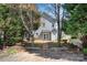 View of the backyard with a concrete patio, and a two story home surrounded by some trees at 232 Faust Rd, Davidson, NC 28036