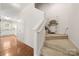 Bright hallway with hardwood floors, staircase chair lift, and kitchen access at 232 Faust Rd, Davidson, NC 28036