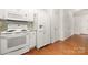 Efficient kitchen featuring white appliances, cabinetry, and hardwood floors at 232 Faust Rd, Davidson, NC 28036