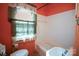 Bathroom featuring a tub, commode, and large window with decorative curtains at 2825 Bancroft St # C, Charlotte, NC 28206