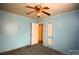 This bedroom has light-blue walls, a ceiling fan, and two doors to other parts of the house at 2825 Bancroft St # C, Charlotte, NC 28206