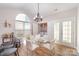 Bright dining area featuring a modern chandelier, ample natural light, and convenient laundry closet at 4108 Twenty Grand Dr, Indian Trail, NC 28079