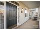 Welcoming front porch featuring a dark wood door, sidelight windows, and brick foundation at 4108 Twenty Grand Dr, Indian Trail, NC 28079