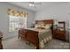 Cozy bedroom features a wooden bed frame, neutral walls, and bright natural lighting at 420 Spring Arbor Ave # 80, Salisbury, NC 28146