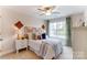 Cozy bedroom with a decorative headboard, patterned pillows, and natural light from a window at 4223 Black Ct # 195, Harrisburg, NC 28075