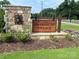 Community entrance sign with stone base, landscaping, mulch, and manicured grass at 4223 Black Ct # 195, Harrisburg, NC 28075