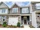 New townhome featuring stone accents, a one-car garage and a covered front entry at 4223 Black Ct # 195, Harrisburg, NC 28075