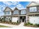 Beautiful new townhome with stone details, siding, a one-car garage, and landscaping at 4223 Black Ct # 195, Harrisburg, NC 28075