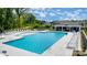 Large swimming pool with ample seating, lounge chairs, and umbrellas near a covered pavilion at 4223 Black Ct # 195, Harrisburg, NC 28075