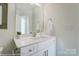 A well-lit bathroom with a single vanity, mirror, and fresh white cabinets providing a clean and modern feel at 4235 Black Ct # 197, Harrisburg, NC 28075