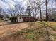 View of the backyard with brick patio and mature trees at 4801 Kipling Dr, Charlotte, NC 28212