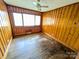 Cozy bedroom featuring wood paneling, hardwood floors and a large bright window at 4801 Kipling Dr, Charlotte, NC 28212