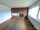 Spacious living room featuring hardwood floors, a decorative brick fireplace, and a large window at 4801 Kipling Dr, Charlotte, NC 28212