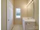 Bathroom view featuring a single vanity, mirror, tile floors, and a window for natural light at 6724 Mallard Park Dr, Charlotte, NC 28262