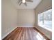 Bright bedroom featuring hardwood floors, a ceiling fan, and a large window that provides ample natural light at 6724 Mallard Park Dr, Charlotte, NC 28262