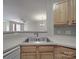 Bright kitchen with laminate countertop, sink, and wooden cabinets, open to the adjacent living area at 6724 Mallard Park Dr, Charlotte, NC 28262