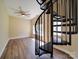 View of the living room with hardwood floors, a large window, ceiling fan, and a spiral staircase at 6724 Mallard Park Dr, Charlotte, NC 28262