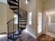 View of the living room with hardwood floors, windows, and a spiral staircase to the upper level at 6724 Mallard Park Dr, Charlotte, NC 28262