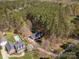 A stunning aerial view highlights a beautiful property with a pool, lush greenery, and mature trees at 7025 Ridgeway Rd, Stanley, NC 28164