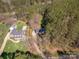 Expansive aerial view showcases the property featuring a pool, lush lawn, and wooded landscape for privacy at 7025 Ridgeway Rd, Stanley, NC 28164