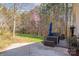 An outdoor back patio with furniture overlooks a lush lawn and treed area, offering a serene view at 7025 Ridgeway Rd, Stanley, NC 28164