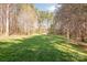 A spacious, well-maintained backyard offers ample green space and privacy surrounded by tall trees at 7025 Ridgeway Rd, Stanley, NC 28164