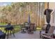 Wooden deck featuring an outdoor table, grill, and patio furniture and overlooking a wooded area at 7025 Ridgeway Rd, Stanley, NC 28164