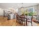 Well-lit dining room features hardwood floors, large windows with backyard views, and modern chandelier at 7025 Ridgeway Rd, Stanley, NC 28164