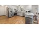 Bright kitchen features stainless steel appliances, white cabinetry, tiled backsplash, and hardwood floors at 7025 Ridgeway Rd, Stanley, NC 28164