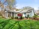 A light blue house with a screened-in porch and beautifully manicured yard with mature landscaping at 800 Water Wheel Ct, Charlotte, NC 28209