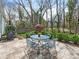 Patio and backyard featuring outdoor dining set, mature trees, and landscaping at 800 Water Wheel Ct, Charlotte, NC 28209