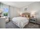 Cozy bedroom with large window, white comforter, and rattan headboard with colorful pillows and lamps at 8637 Miles Gap Rd, Indian Land, SC 29707