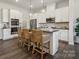 Modern kitchen with white cabinets, stainless steel appliances, dark counters and center island with seating at 8637 Miles Gap Rd, Indian Land, SC 29707